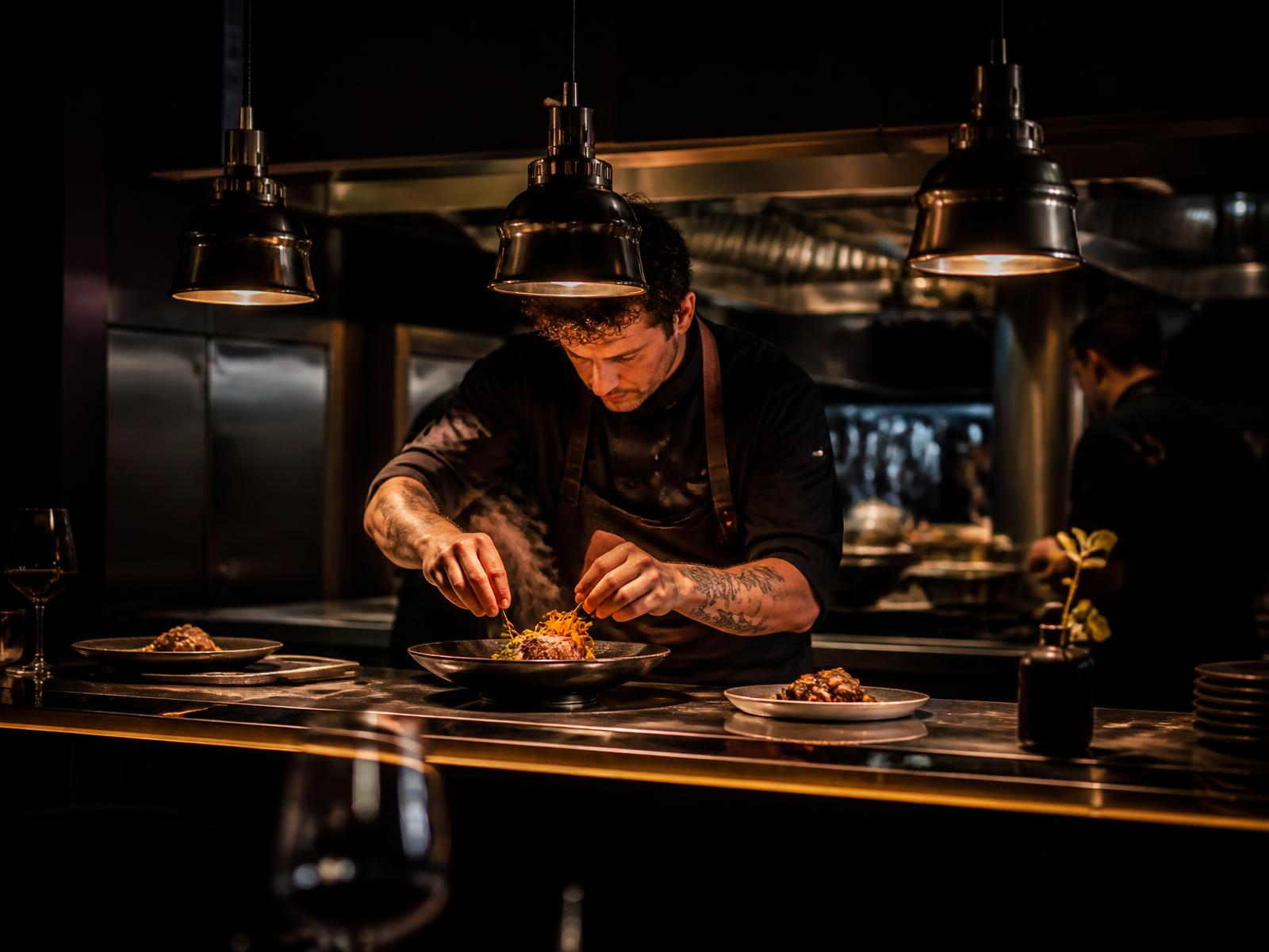 Chef finalizando um prato em cozinha profissional de alta gastronomia